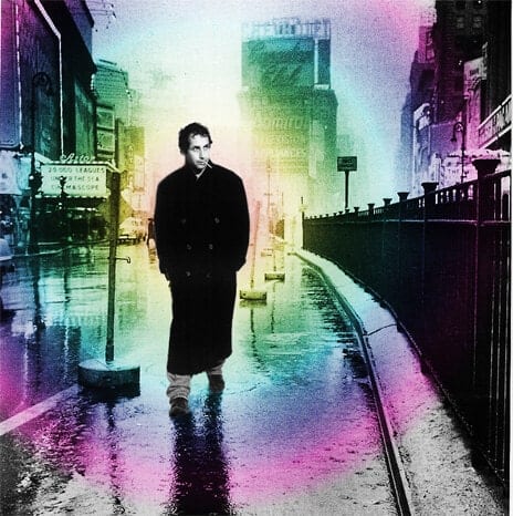 A man in a dark coat walks beside railings in a street portrait tinted with bright colours.